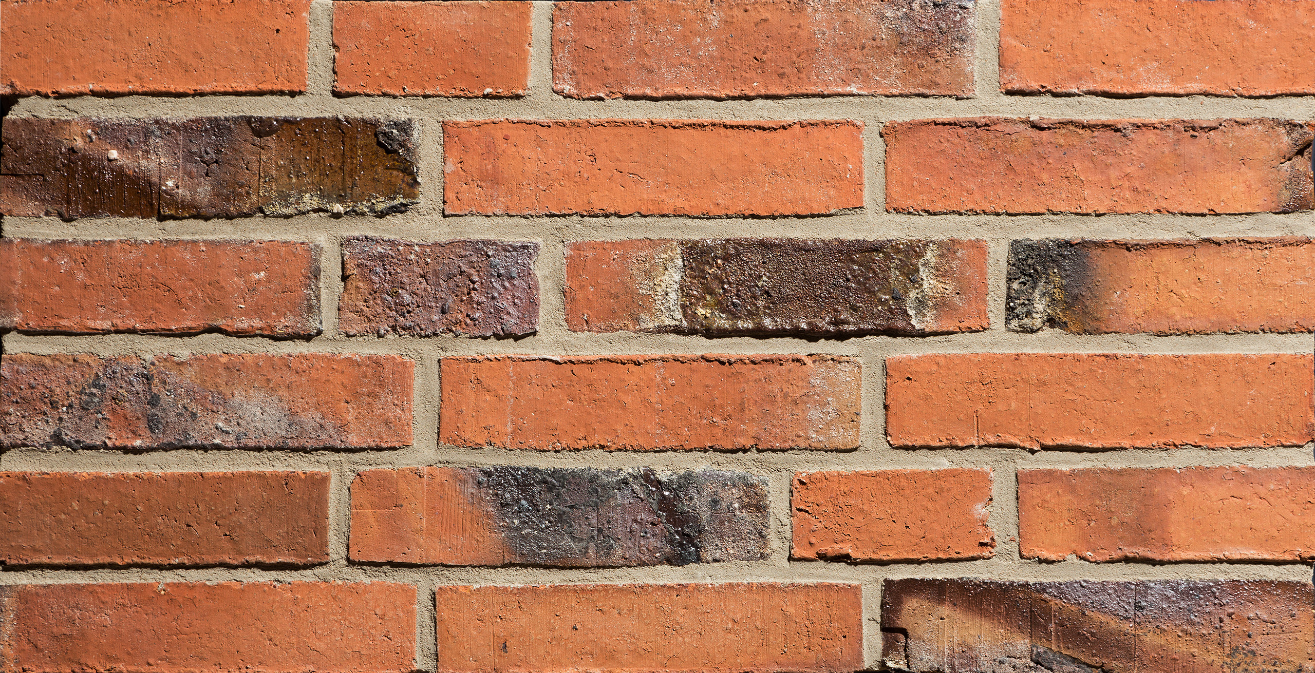 Mustertafel mit 6 orangefarben-braunen Klinkern mit Kohleaufbrennungen und rauer Oberfläche