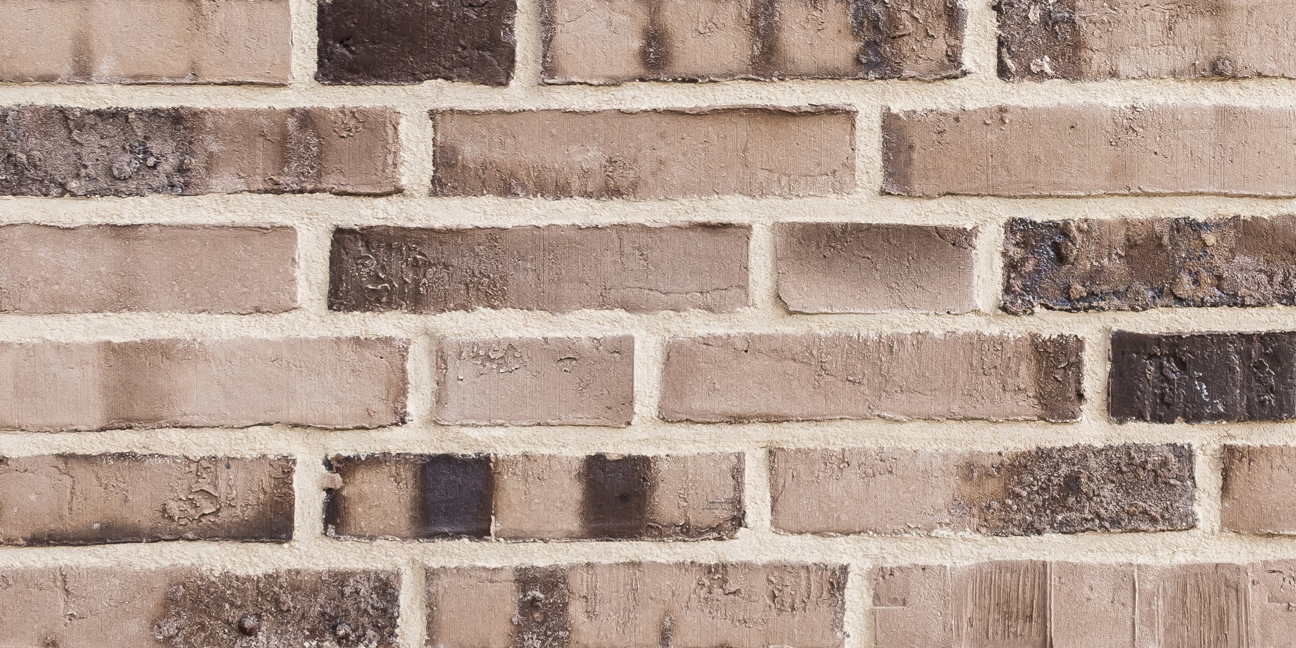 Mustertafel mit 6 Reihen creme-brauner Klinker mit Kohleaufbrennungen