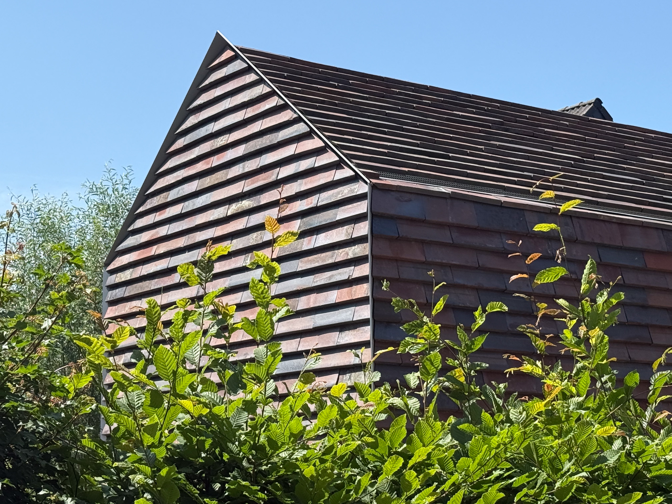 Seitenansicht Anbau mit Keramikschindeln CradleTop CTP Danzig in rot-braun mit Kohleaufbrennungen