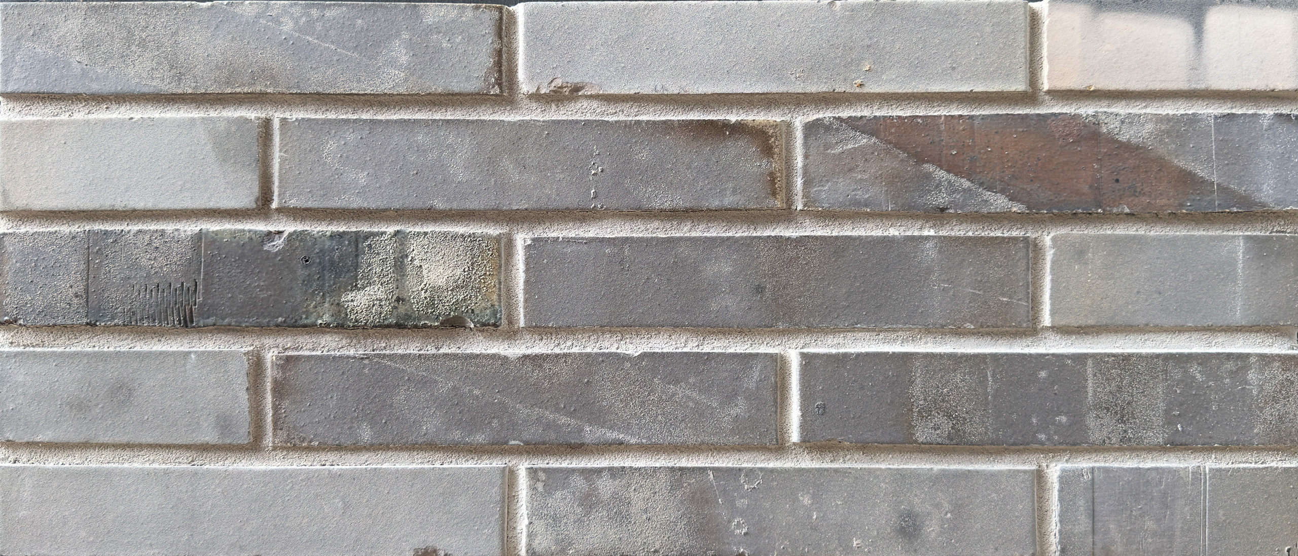 Mustertafel mit 5 Reihen hellgrauer Steine mit einem dunkleren und einem mit Rückseiten Setzstreifen